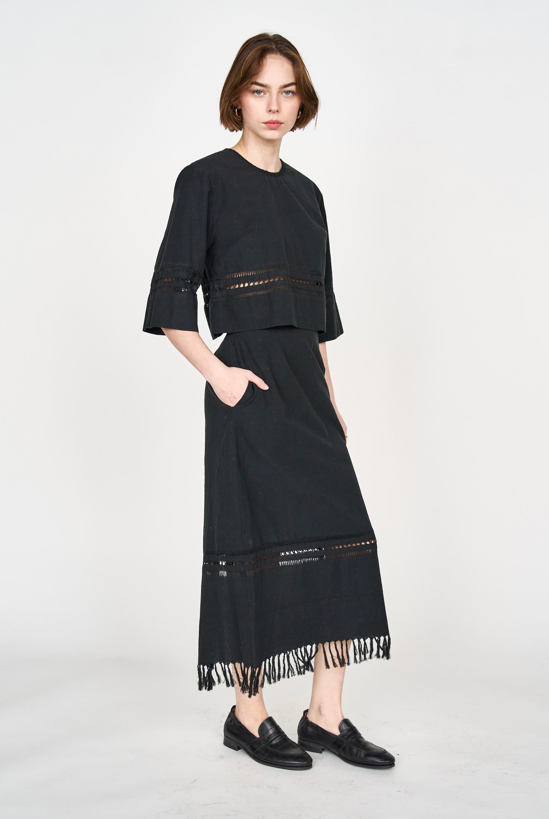 Girl wearing MIRTH women's fringe cutout quarter sleeve sintra top in black cotton