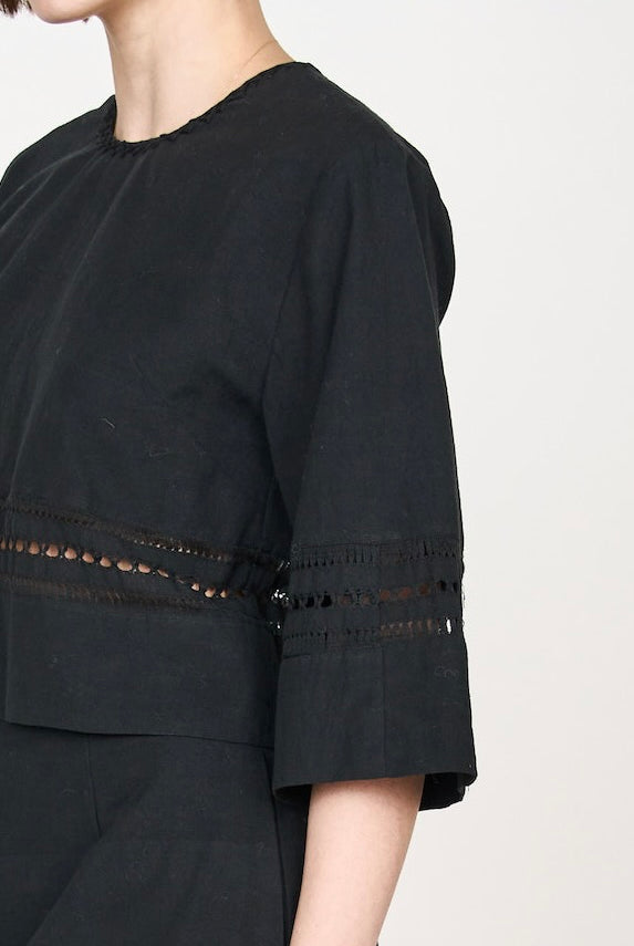 Girl wearing MIRTH women's fringe cutout quarter sleeve sintra top in black cotton