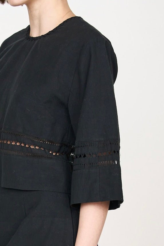 Girl wearing MIRTH women's fringe cutout quarter sleeve sintra top in black cotton