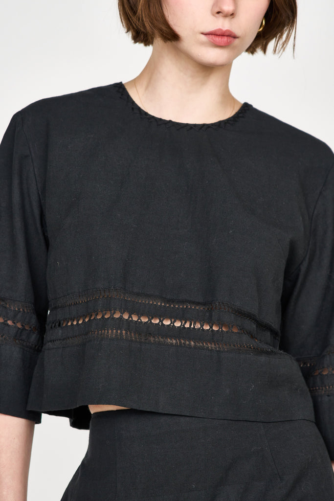 Girl wearing MIRTH women's fringe cutout quarter sleeve sintra top in black cotton