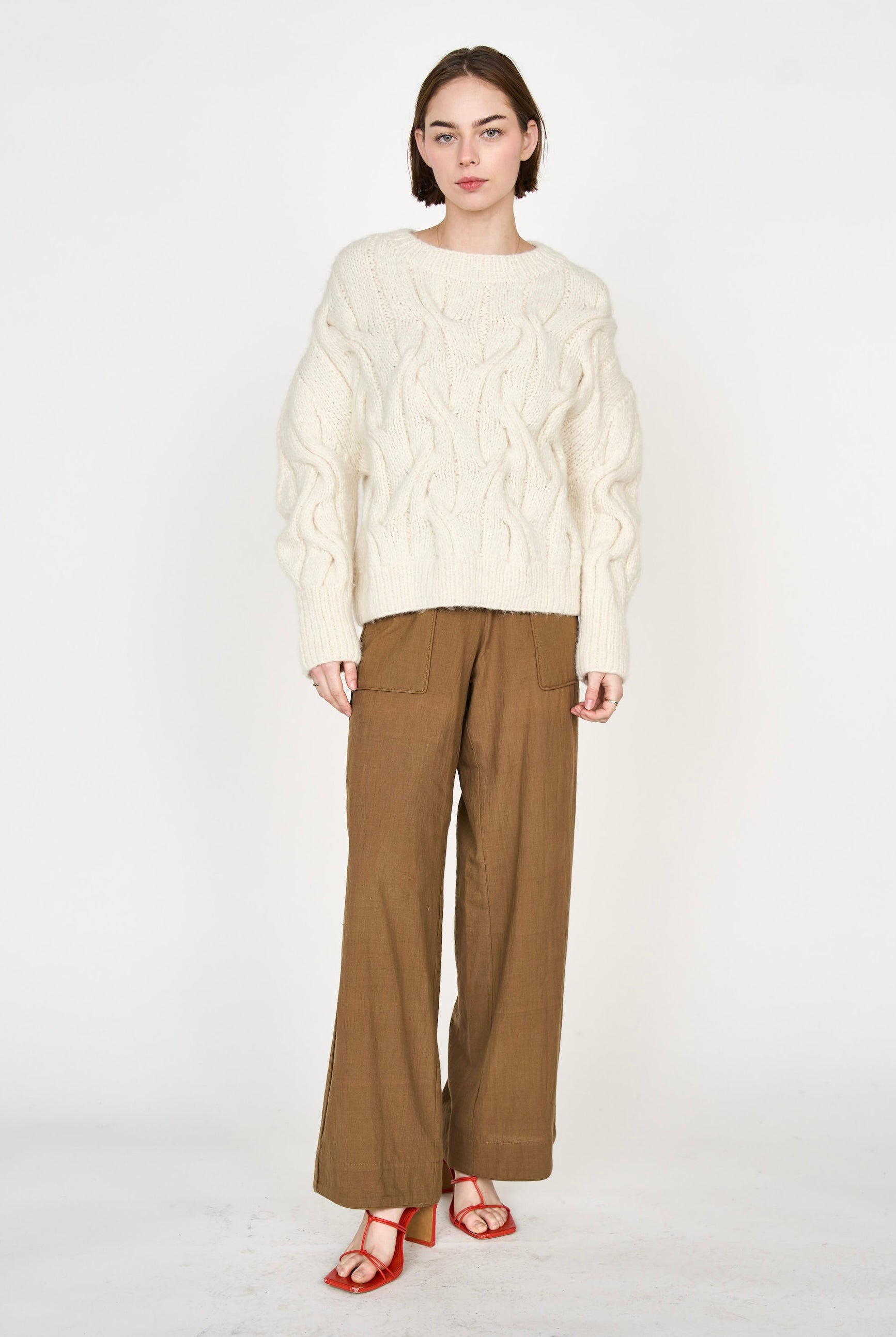 Girl wearing MIRTH women's handknit cortina cable pullover sweater in cream white wool