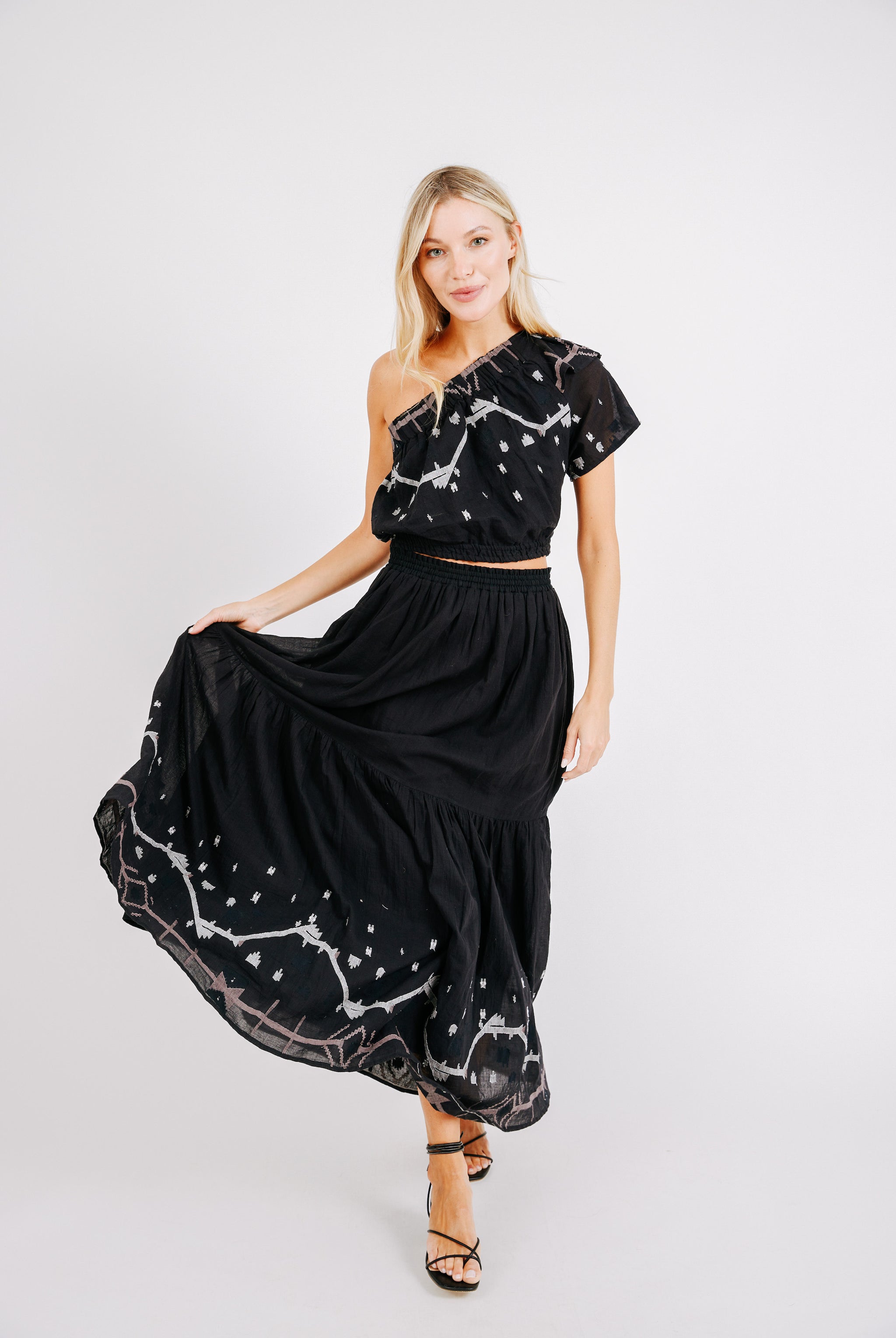 Girl wearing MIRTH women's cropped one shoulder paros top set in handloomed black carnival jamdani