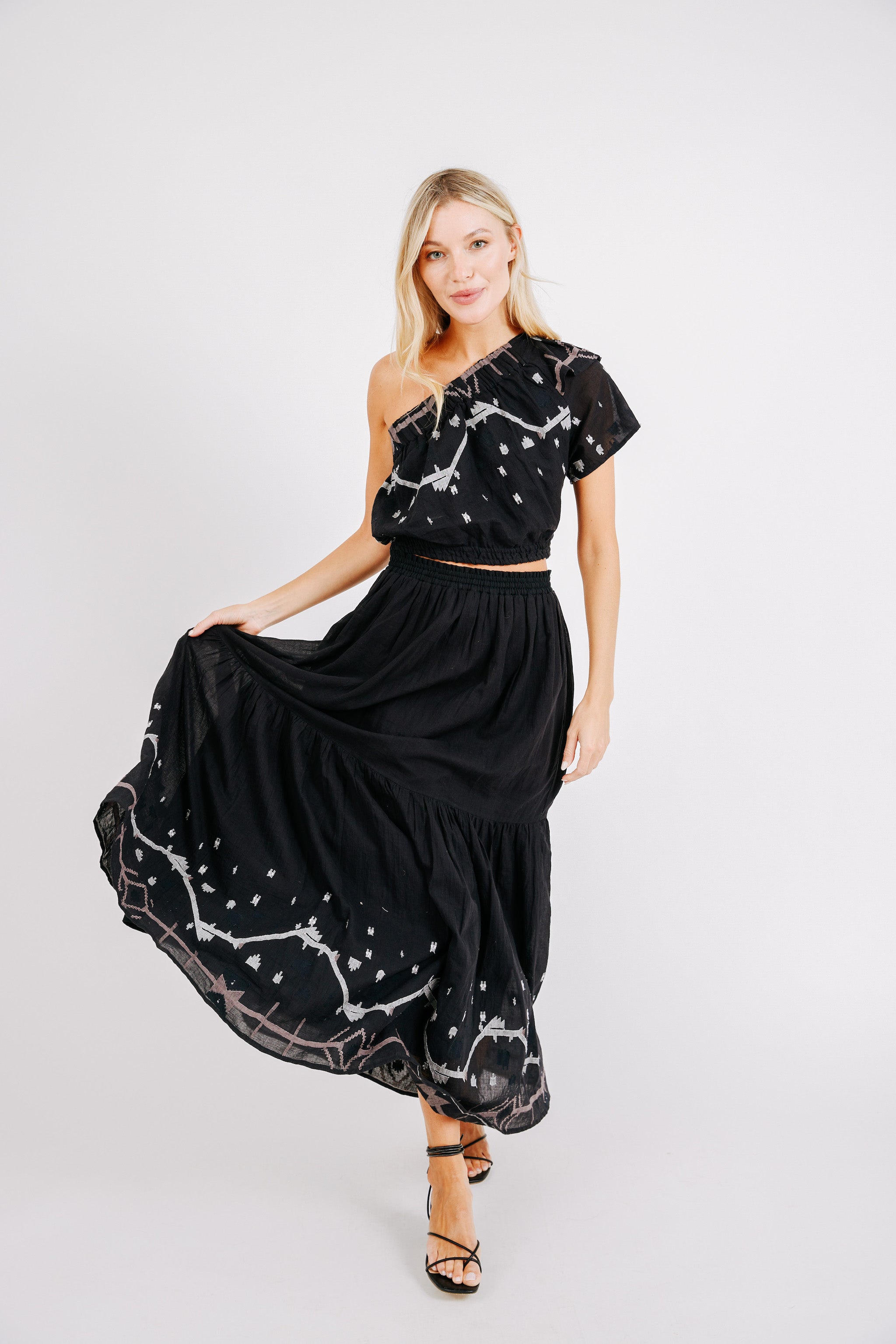 Girl wearing MIRTH women's cropped one shoulder paros top set in handloomed black carnival jamdani