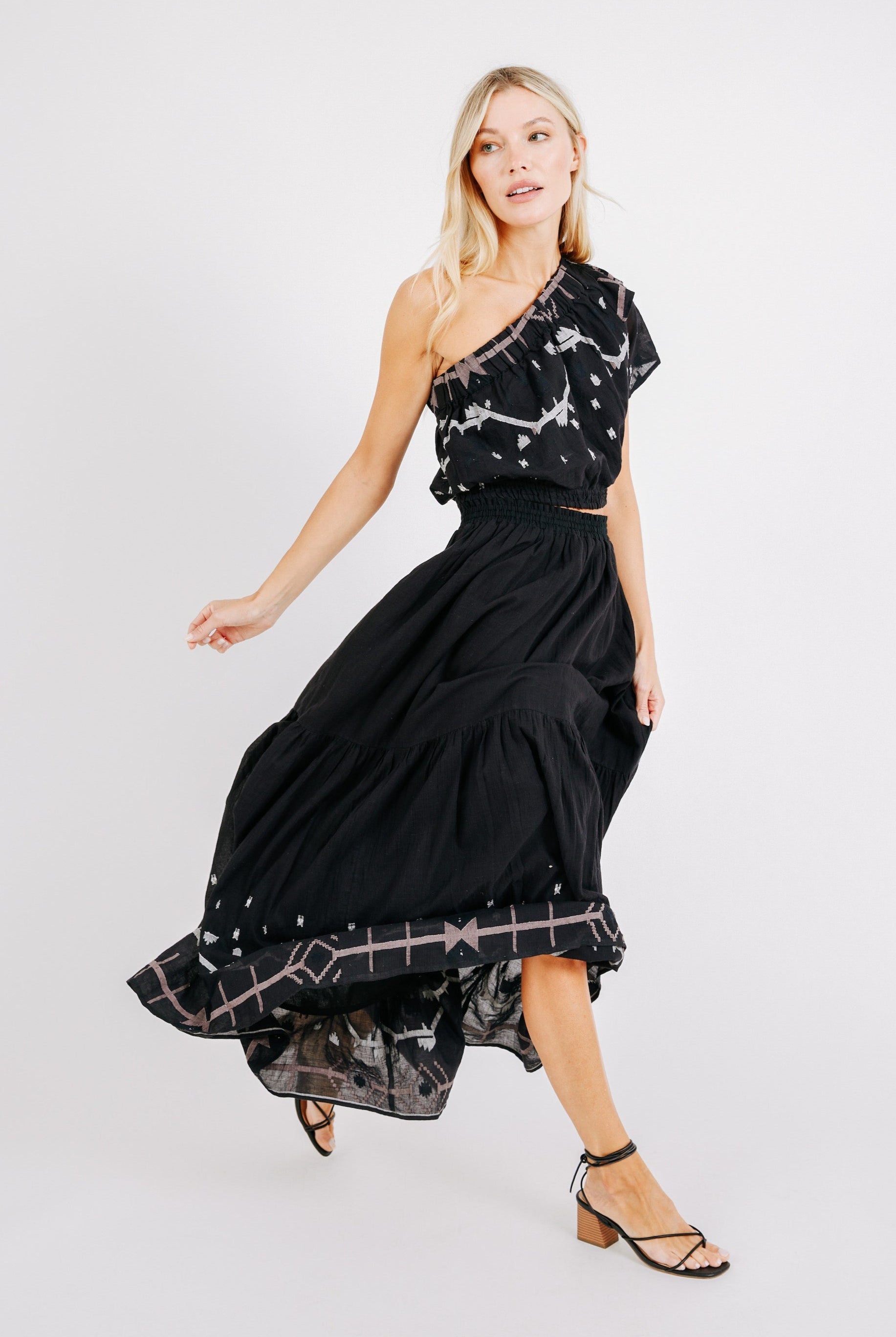 Girl wearing MIRTH women's long flowy paros skirt set in handloomed black carnival jamdani