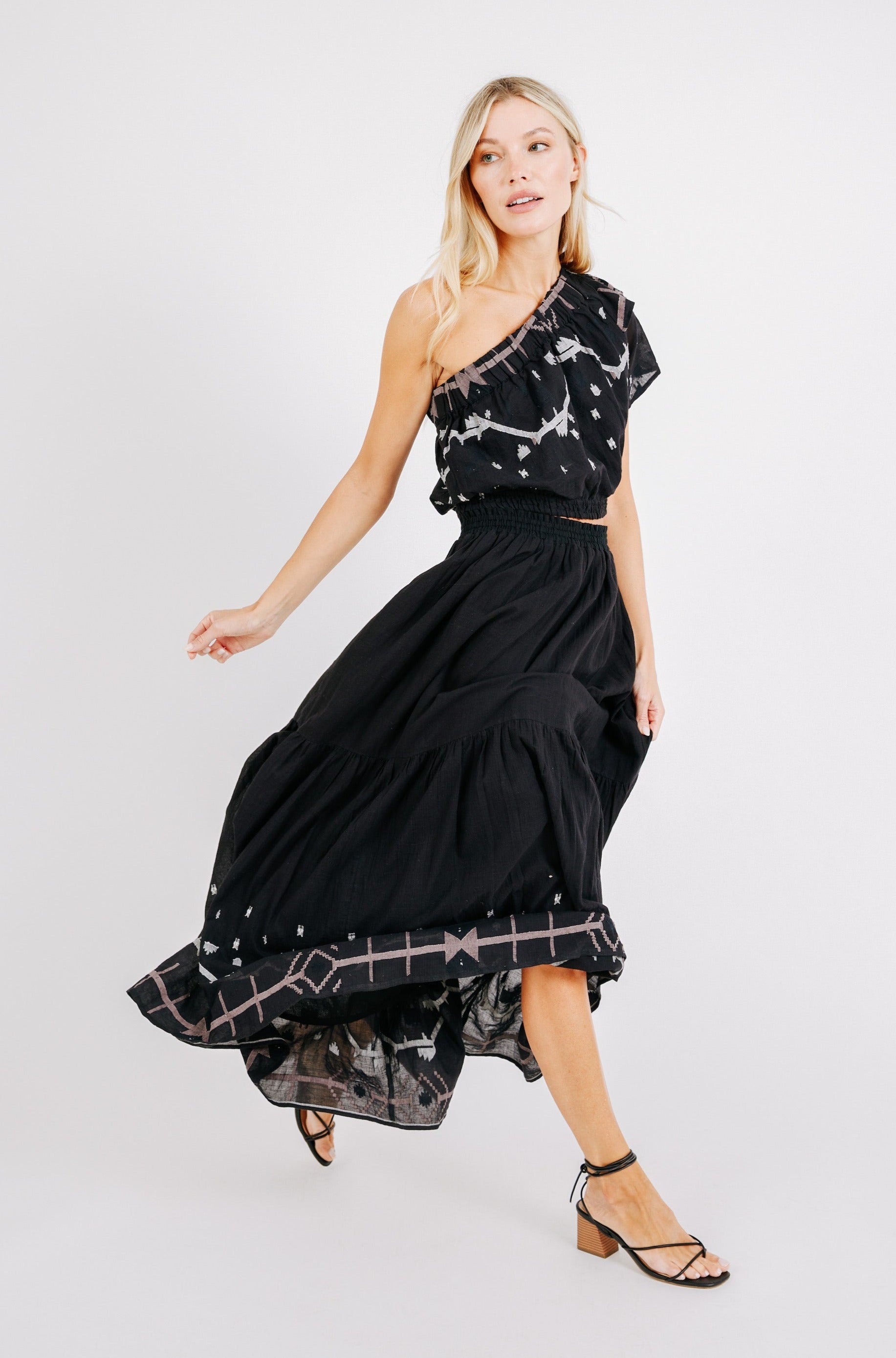 Girl wearing MIRTH women's long flowy paros skirt set in handloomed black carnival jamdani