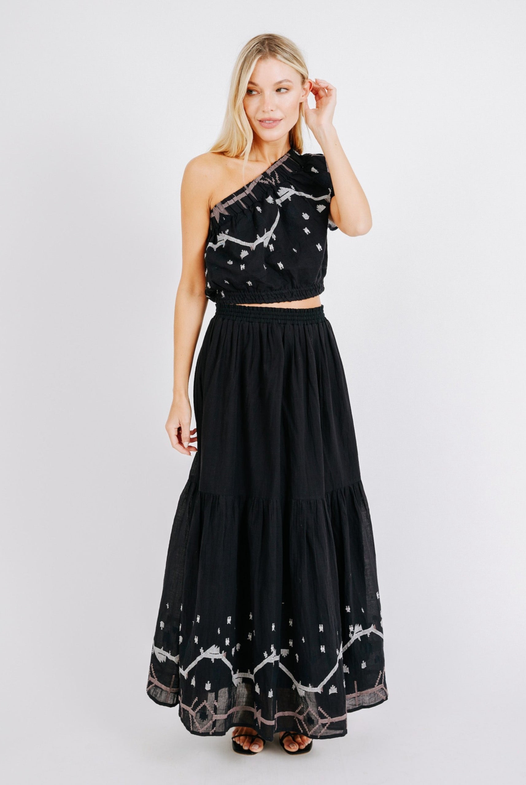 Girl wearing MIRTH women's long flowy paros skirt set in handloomed black carnival jamdani