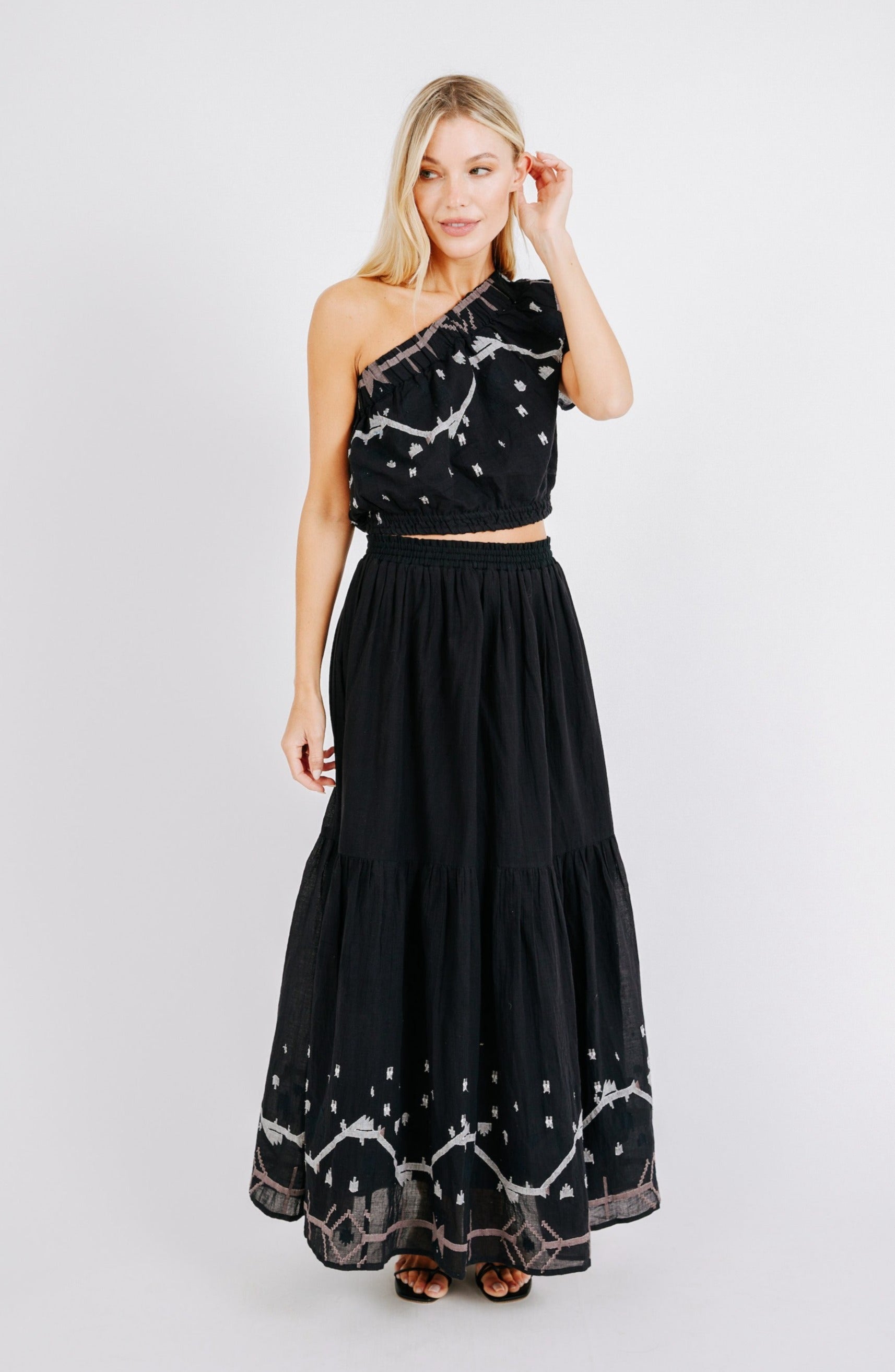 Girl wearing MIRTH women's long flowy paros skirt set in handloomed black carnival jamdani