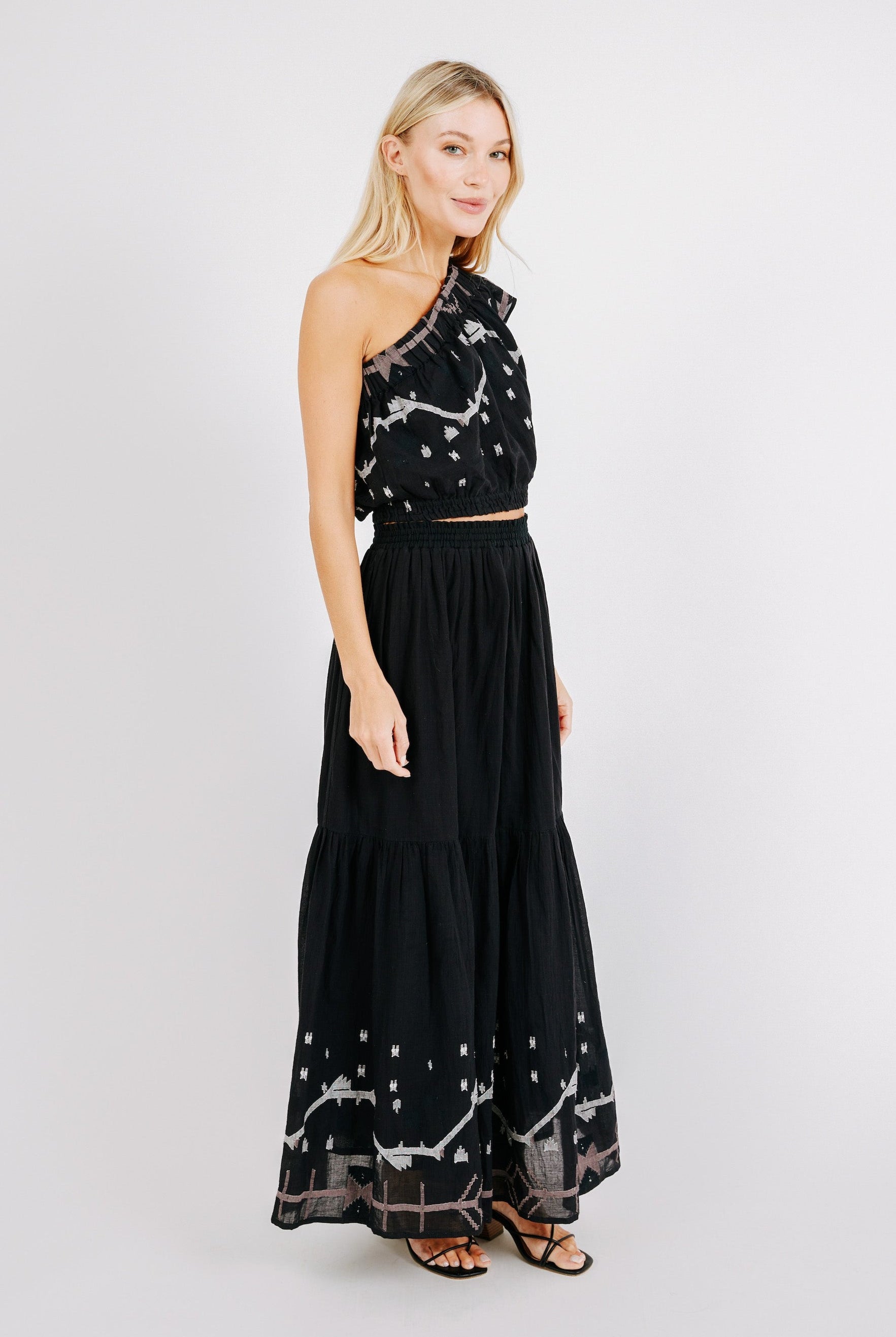 Girl wearing MIRTH women's long flowy paros skirt set in handloomed black carnival jamdani