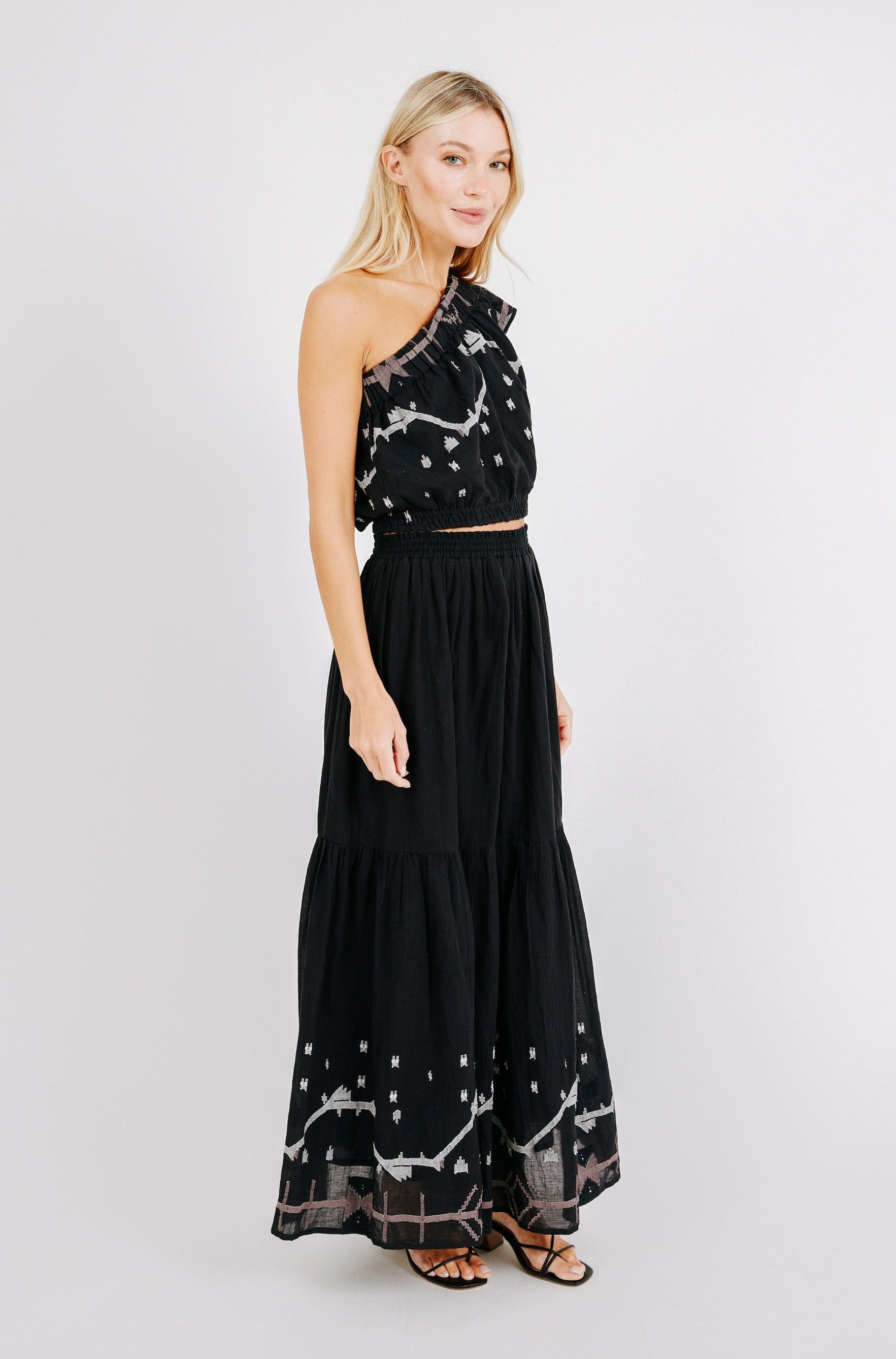 Girl wearing MIRTH women's long flowy paros skirt set in handloomed black carnival jamdani