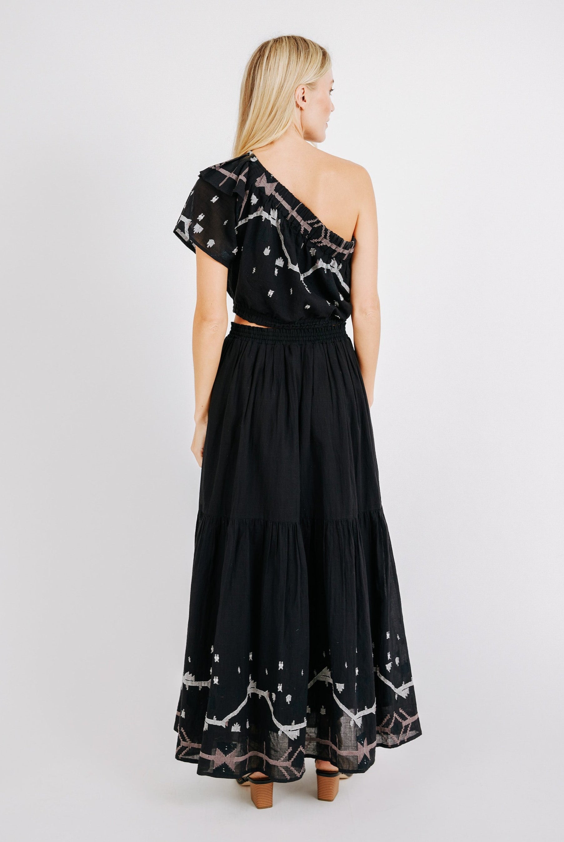 Girl wearing MIRTH women's long flowy paros skirt set in handloomed black carnival jamdani