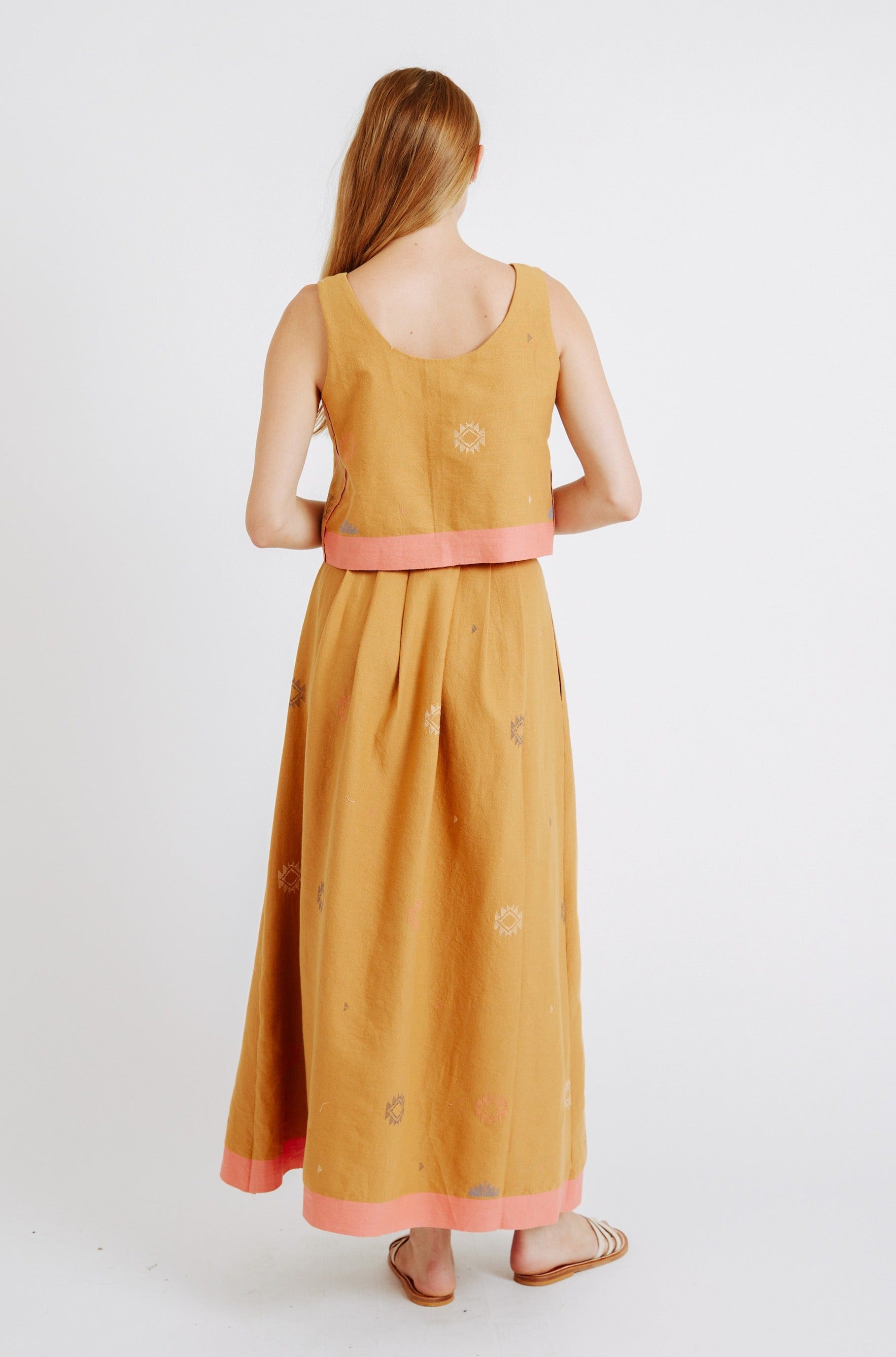 Girl wearing MIRTH women's long lucerne skirt set in handloomed sedona orange jamdani