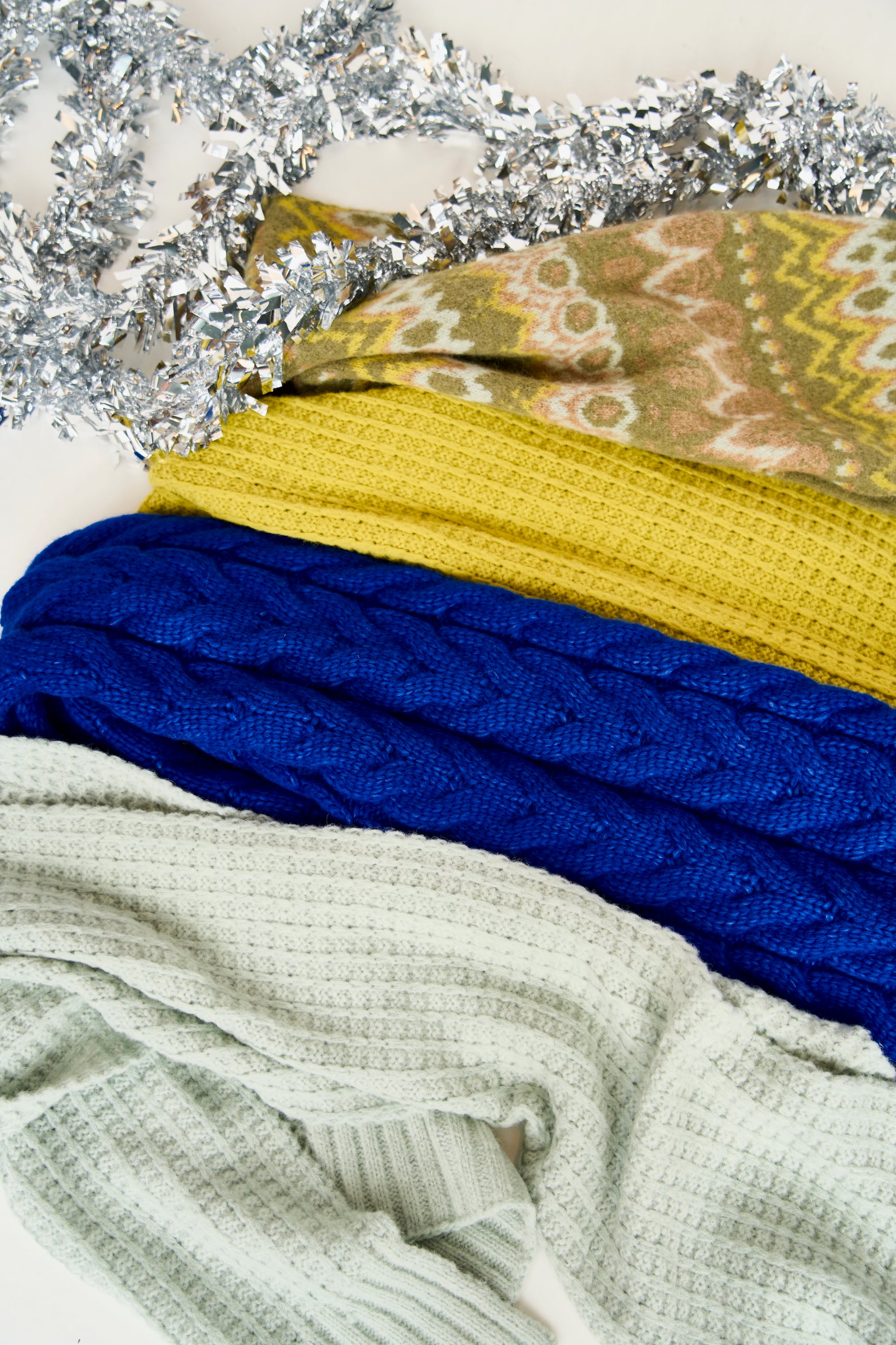 Stack of colorful textured cloths with a decorative background