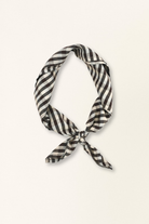 Black and white checkered scarf tied on a beige background