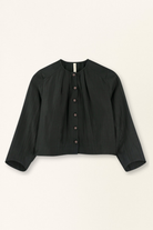 Black jacket with button details on a beige background