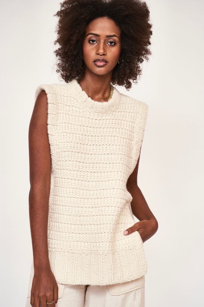 Girl wearing MIRTH women's sleeveless carmel open side knit sweater vest in snow white alpaca wool