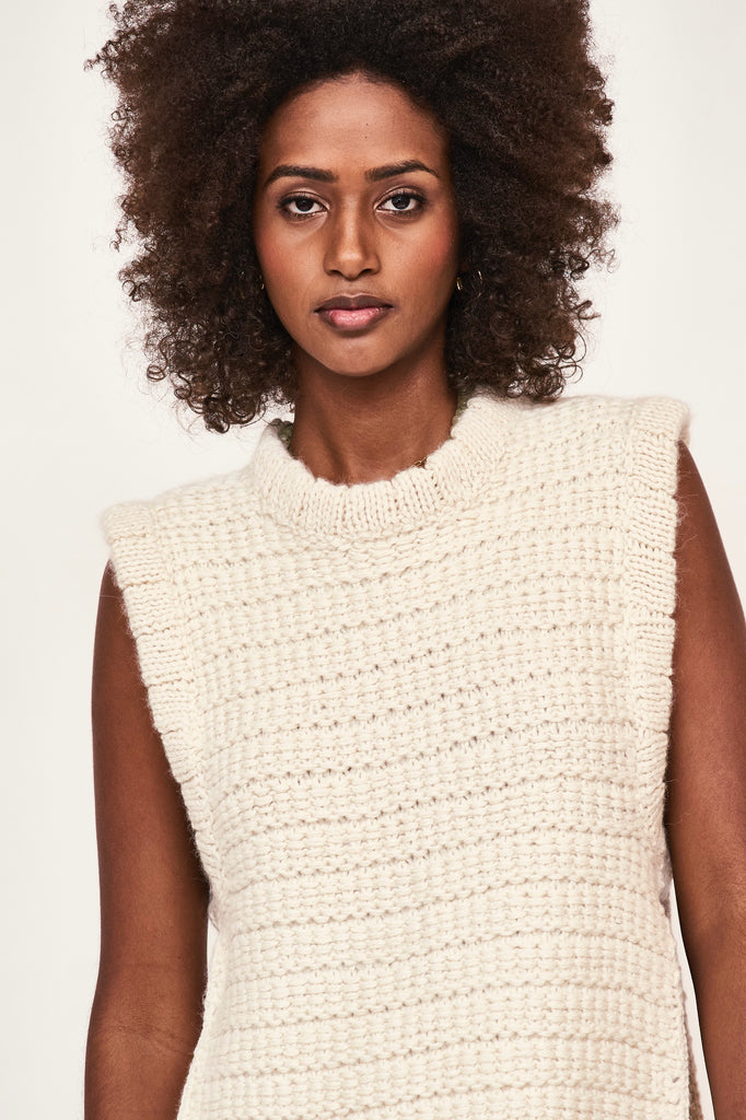 Girl wearing MIRTH women's sleeveless carmel open side knit sweater vest in snow white alpaca wool