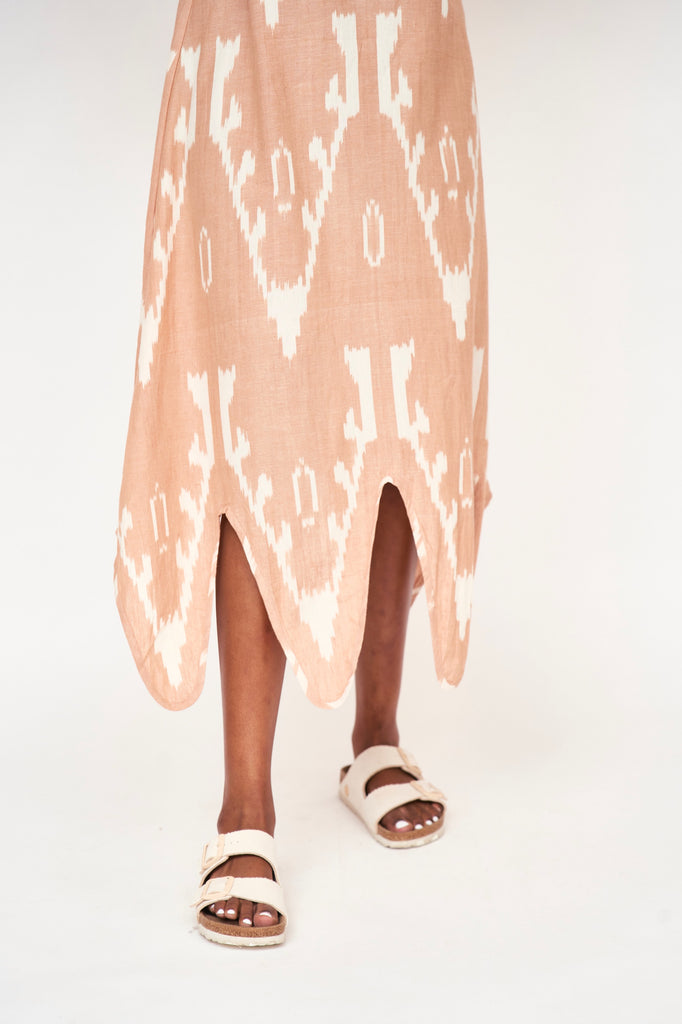 Girl wearing MIRTH women's puff sleeve v neck scallop hem cassis long dress in conch ikat peach cotton