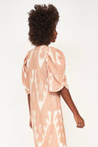 Girl wearing MIRTH women's puff sleeve v neck cassis long dress in conch ikat peach cotton