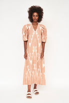 Girl wearing MIRTH women's puff sleeve v neck cassis long dress in conch ikat peach cotton