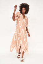 Girl wearing MIRTH women's puff sleeve v neck scallop hem cassis long dress in conch ikat peach cotton