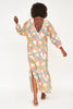 Girl wearing MIRTH women's v neck open back belted curacao long caftan in waterlily print cotton
