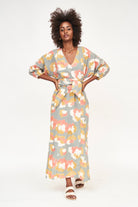 Girl wearing MIRTH women's v neck open back belted curacao long caftan in waterlily print cotton