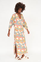 Girl wearing MIRTH women's v neck open back belted curacao long caftan in waterlily print cotton