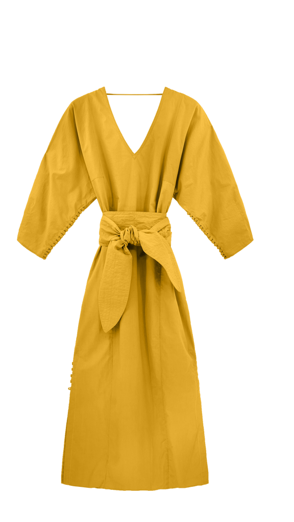 Girl wearing MIRTH women's v neck open back belted curacao long caftan in gilded yellow poplin