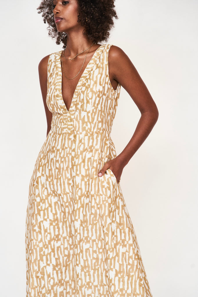 Girl wearing MIRTH women's v neck open back sleeveless cyprus long dress in driftwood brown print cotton silk