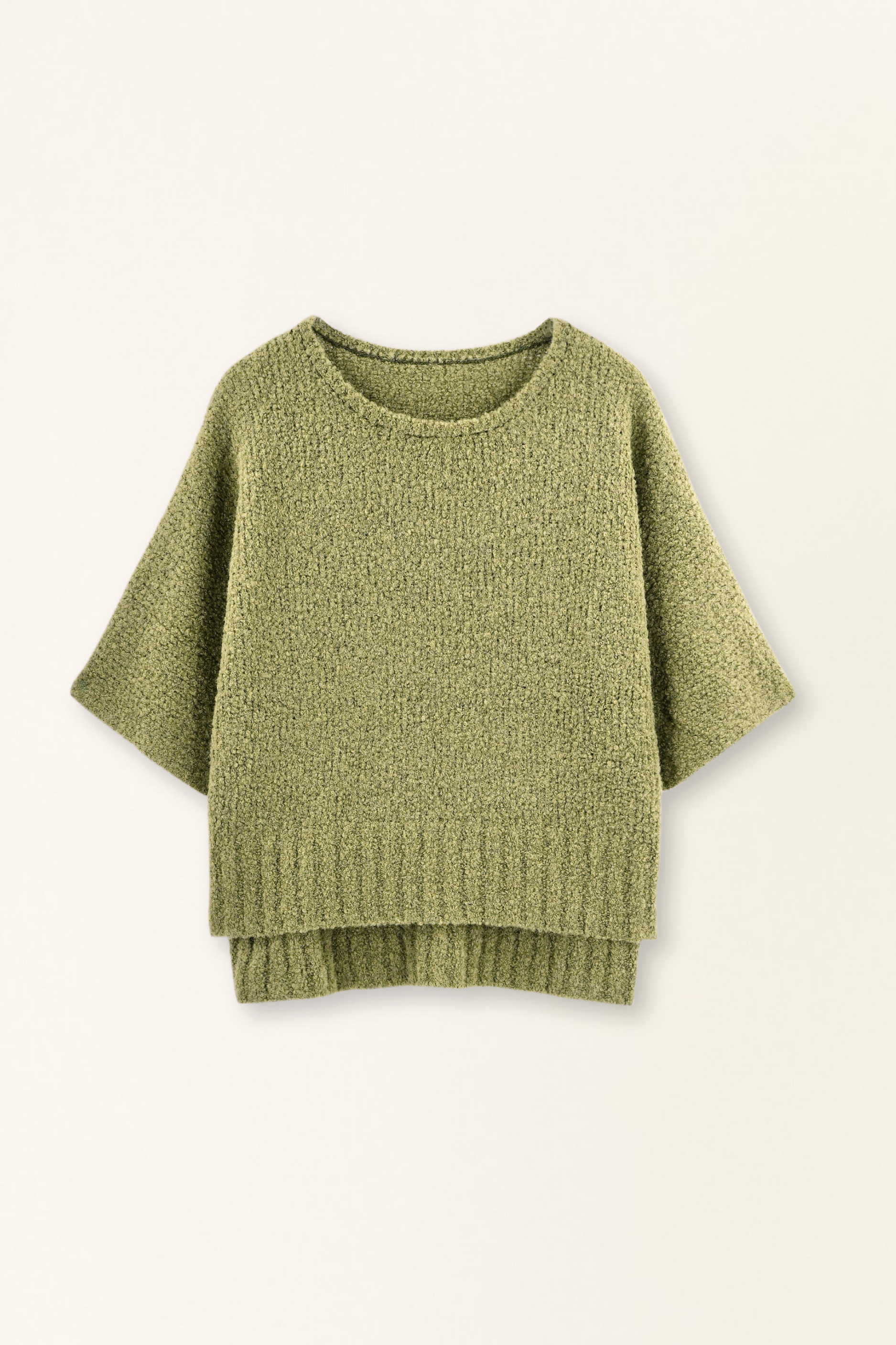 Green knitted sweater on a light beige background