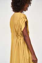 Girl wearing MIRTH women's midi v neck pleated korcula dress in gilded yellow cotton