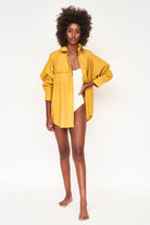 Girl wearing MIRTH women's button up long sleeve kyoto shirt in gilded yellow cotton