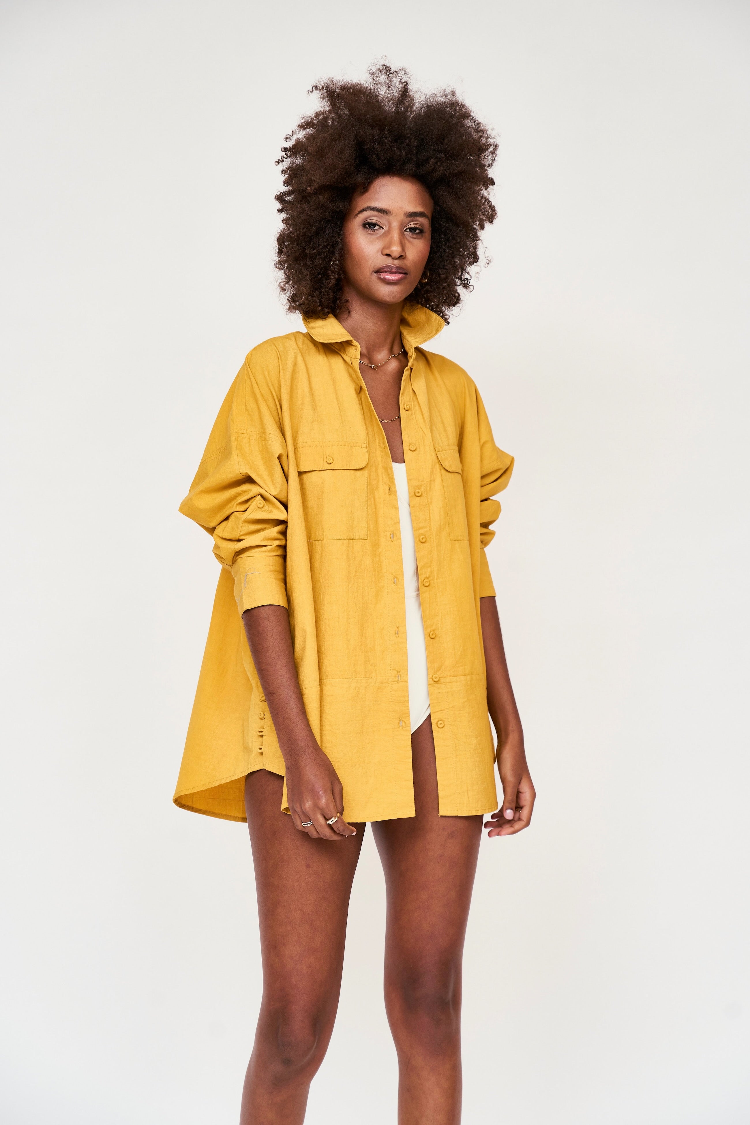 Girl wearing MIRTH women's button up long sleeve kyoto shirt in gilded yellow cotton