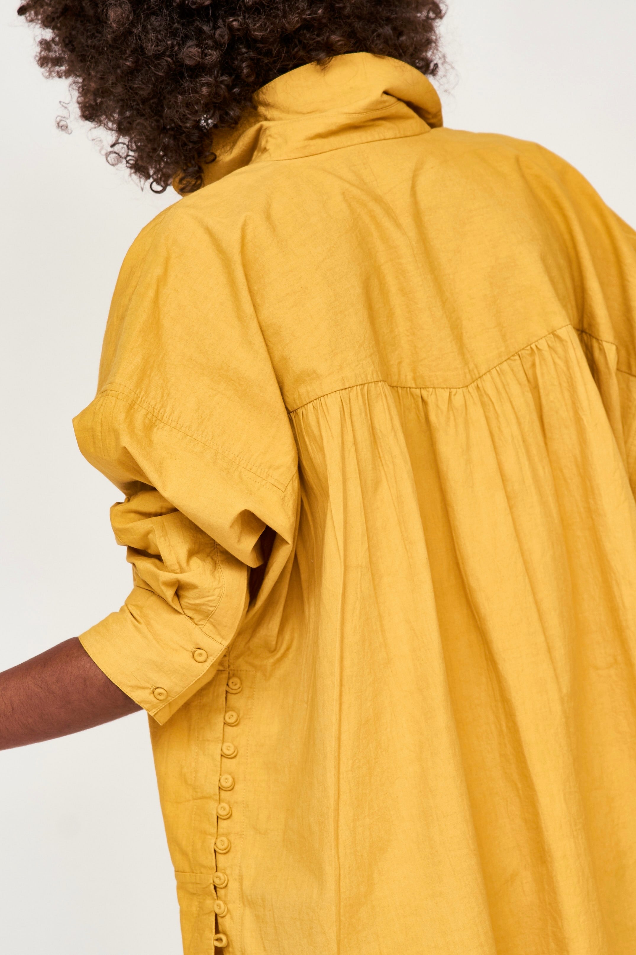 Girl wearing MIRTH women's button up long sleeve kyoto shirt in gilded yellow cotton