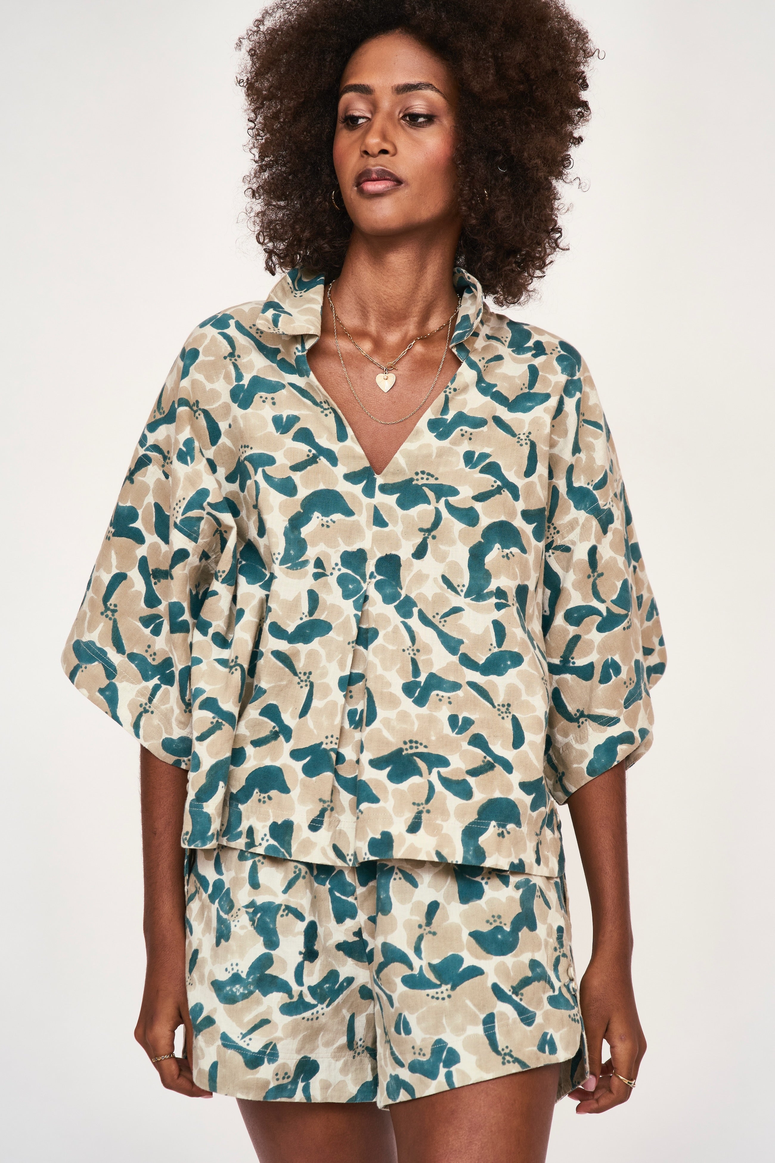 Girl wearing MIRTH women's v neck collared three quarter sleeve lanai top in plumeria blue floral print cotton