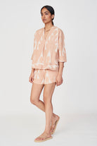 Girl wearing MIRTH women's v neck three quarter sleeve camden top in peach conch ikat handloomed cotton