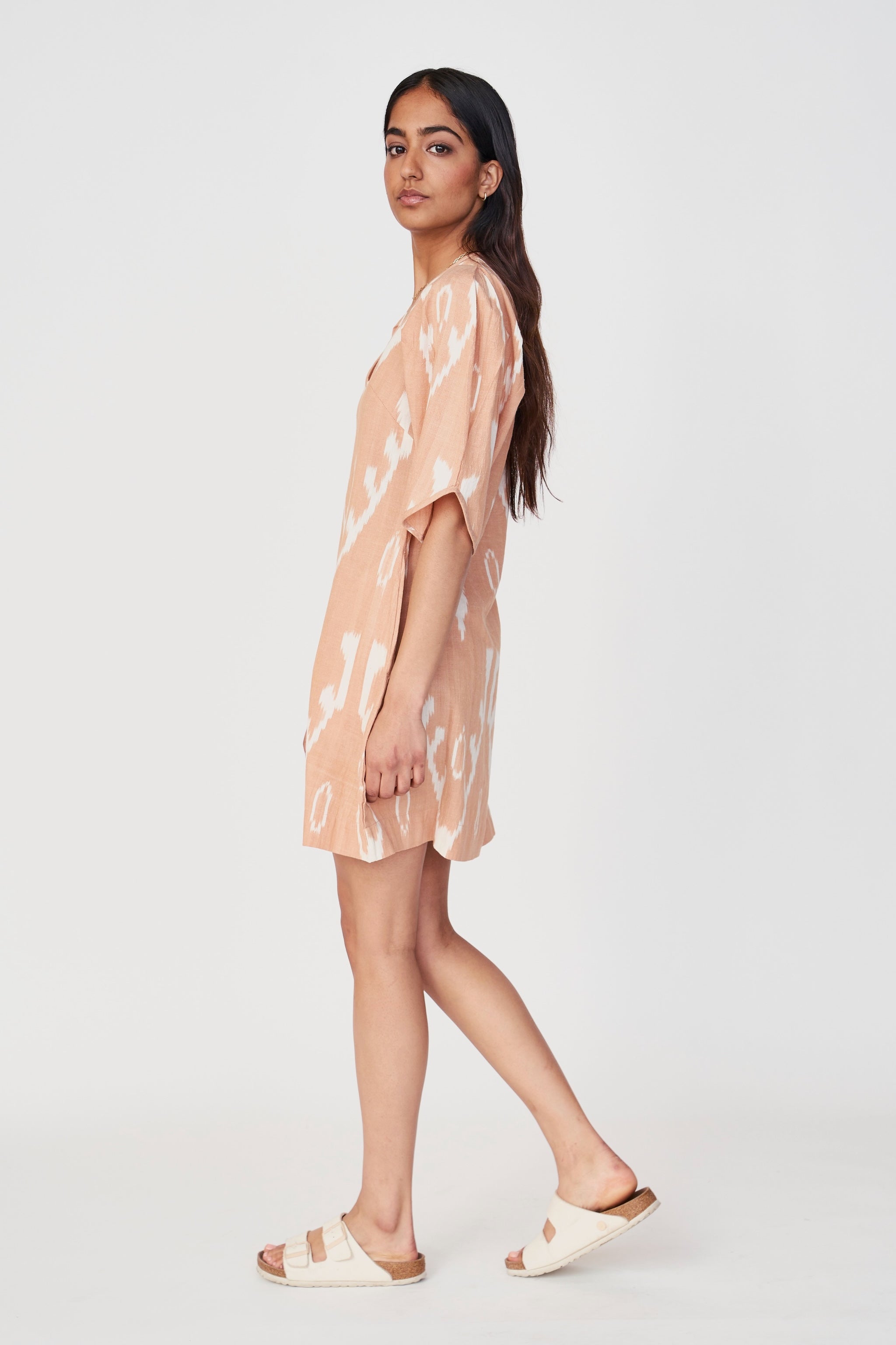 Girl wearing MIRTH women's puff sleeve v neck cassis short dress in conch ikat peach cotton