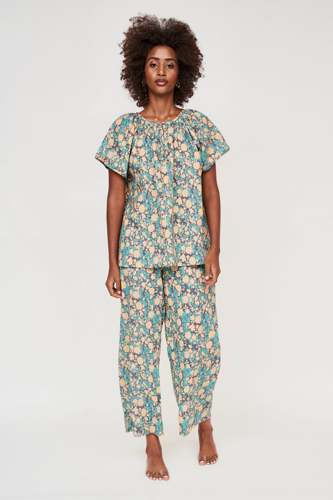 Girl wearing MIRTH women's short sleeve pajama pant set in onyx bloom floral cotton