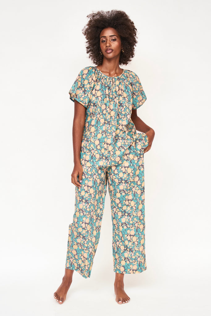 Girl wearing MIRTH women's short sleeve pajama pant set in onyx bloom floral cotton