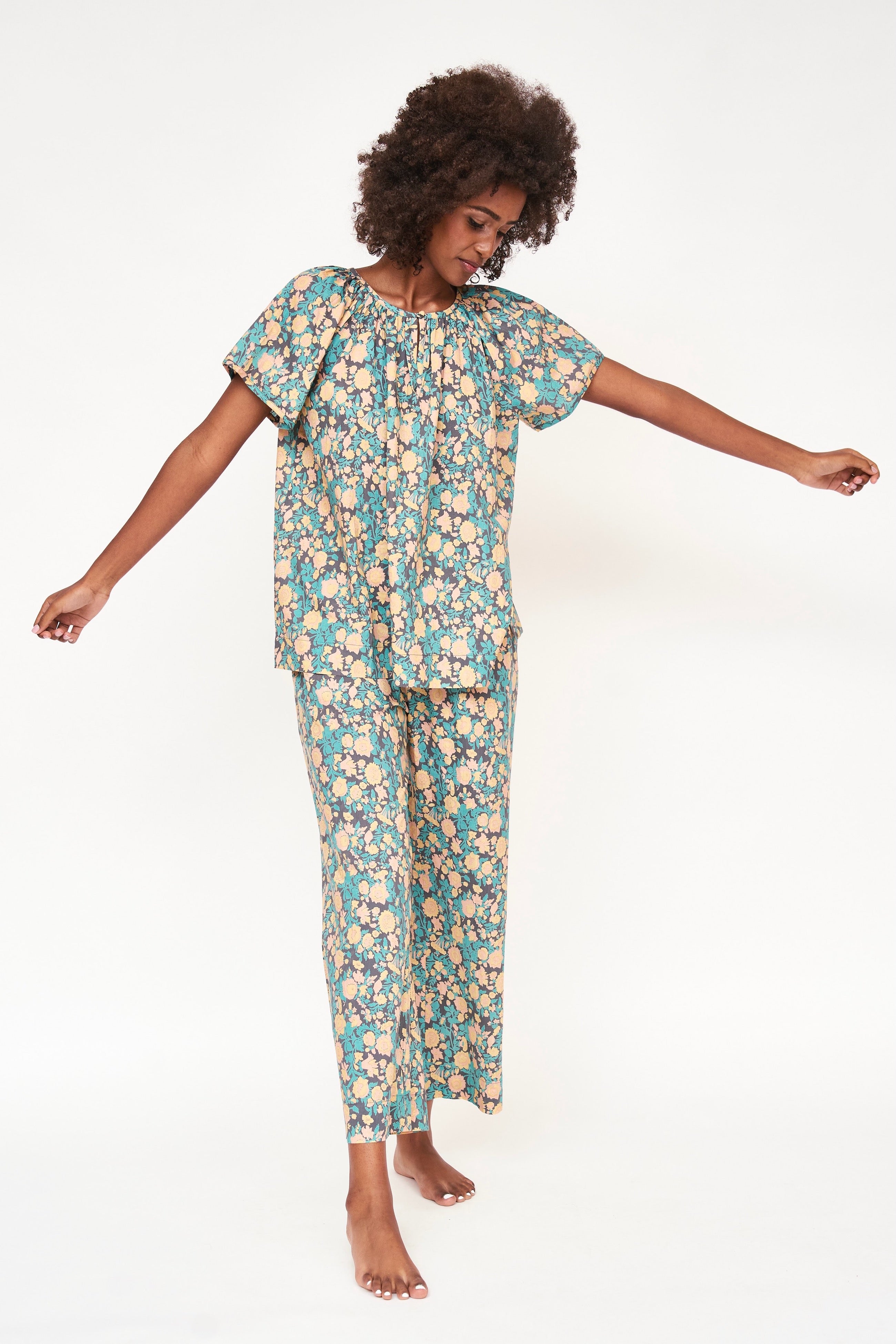 Girl wearing MIRTH women's short sleeve pajama pant set in onyx bloom floral cotton