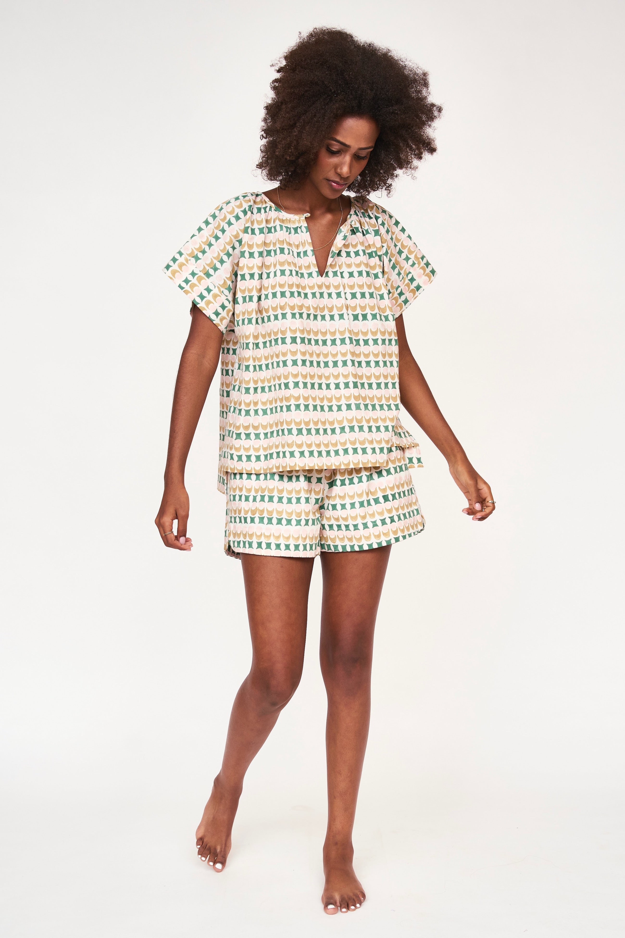 Girl wearing MIRTH women's short sleeve pajama short set in jawbreaker green cotton