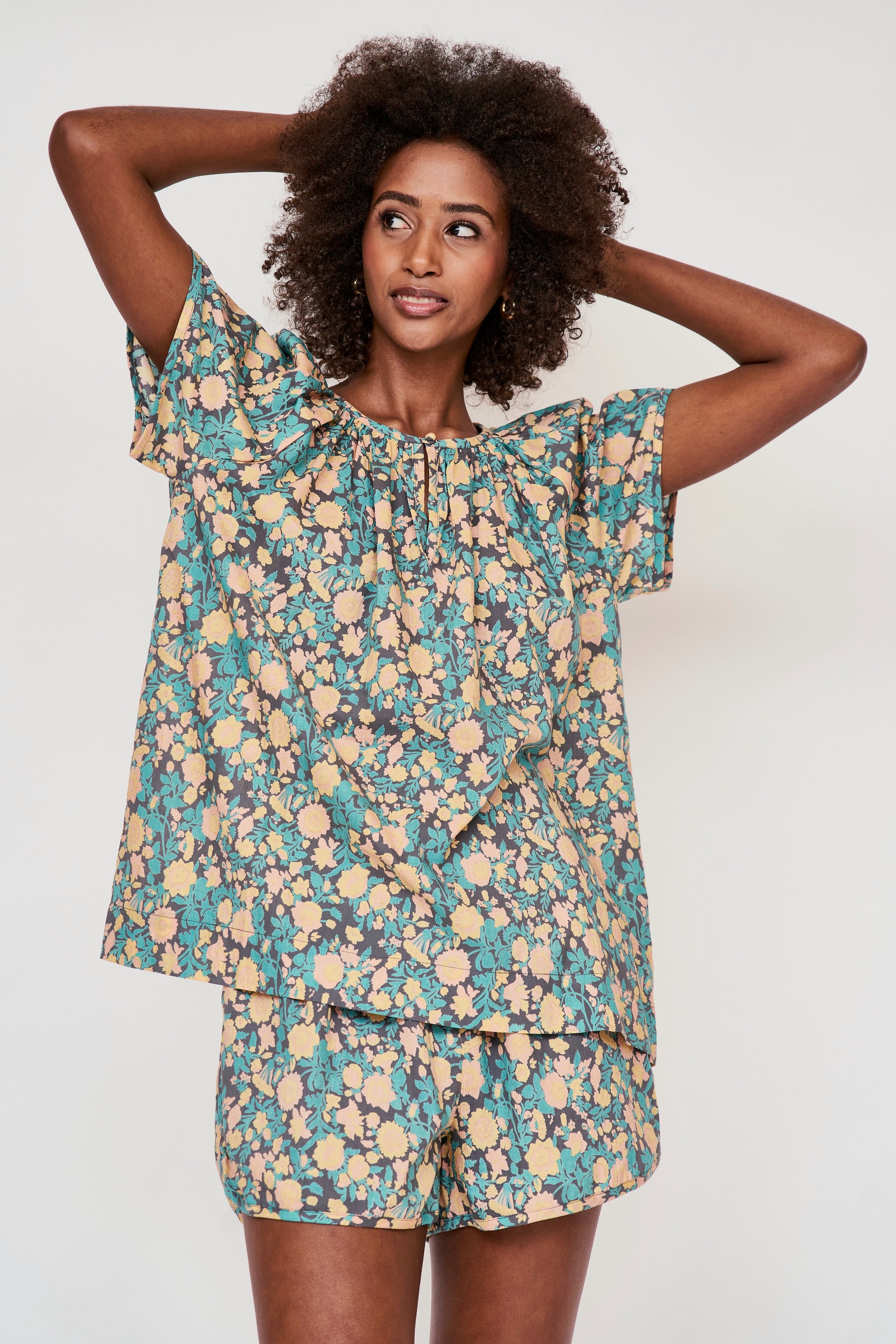 Girl wearing MIRTH women's short sleeve pajama short set in onyx bloom floral cotton