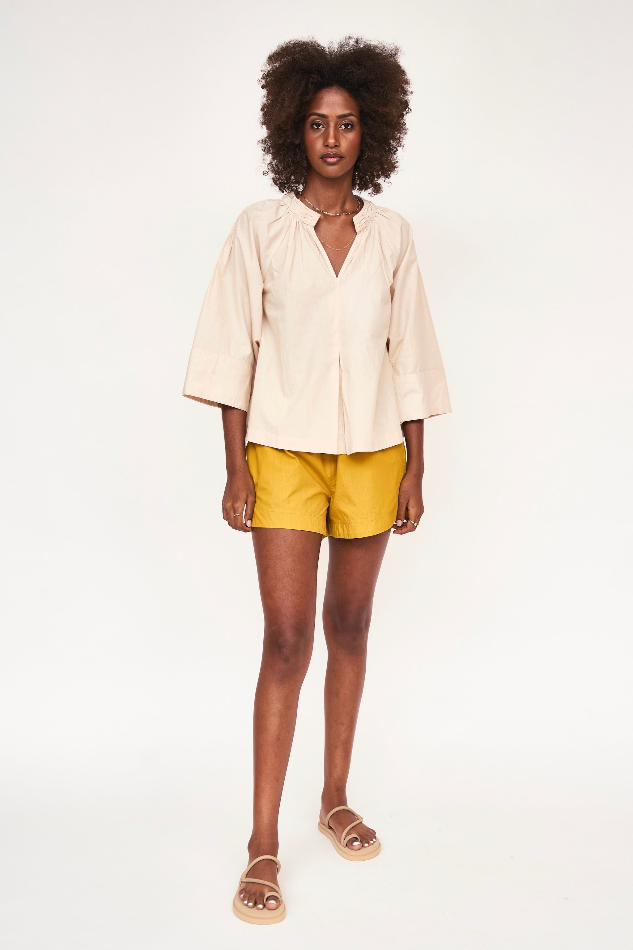 Girl wearing MIRTH women's wide leg elastic track shorts in gilded yellow cotton