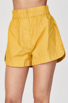 Girl wearing MIRTH women's wide leg elastic track shorts in gilded yellow cotton