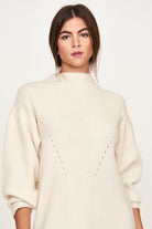 Girl wearing MIRTH women's knit pichu pichu sweater dress in ivory white wool