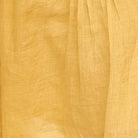 Girl wearing MIRTH women's v neck pleated pull string malta lined coverup short dress in gilded yellow cotton