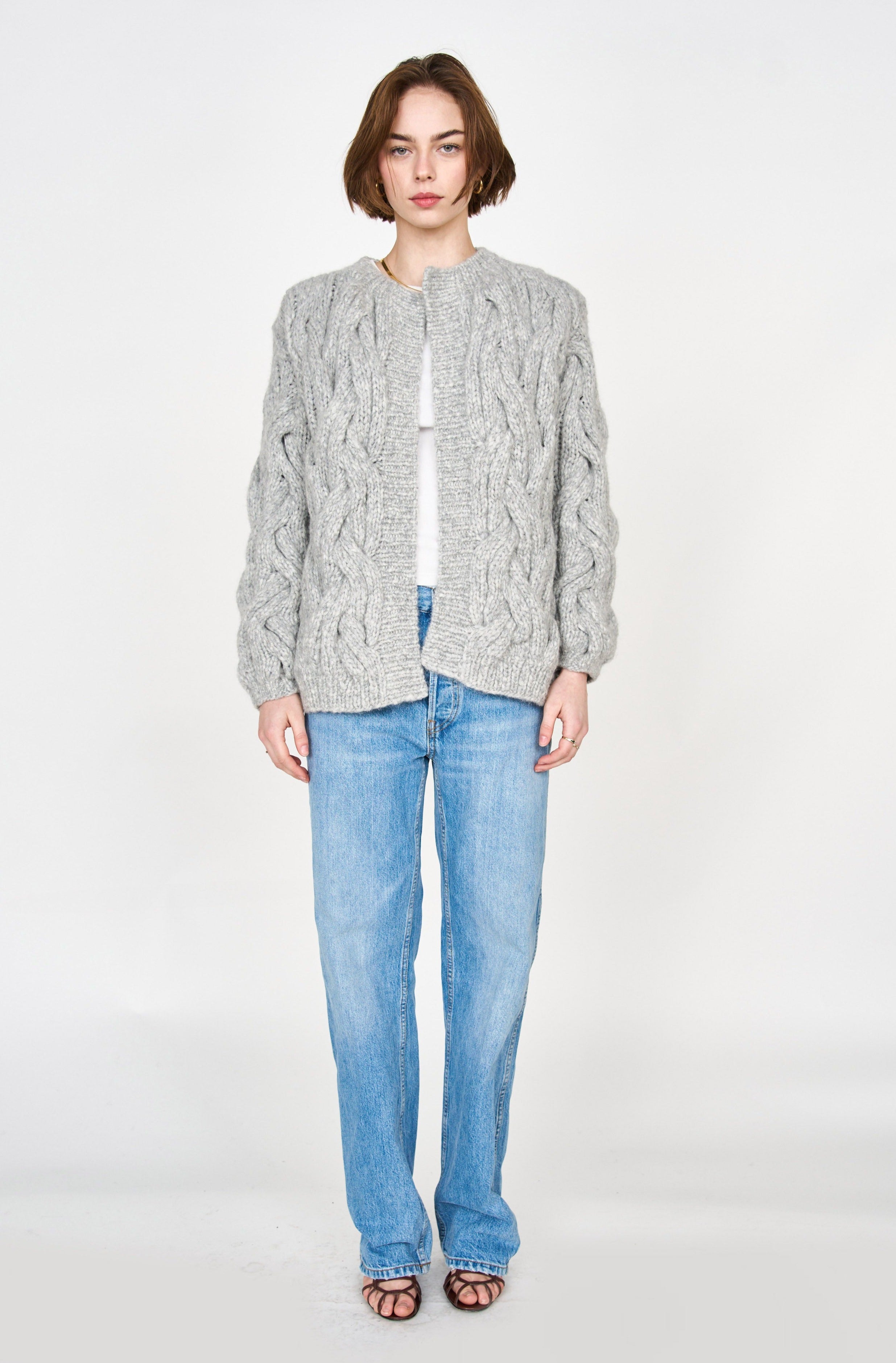 Girl wearing MIRTH women's handknit cortina cable cardigan sweater in dove grey wool