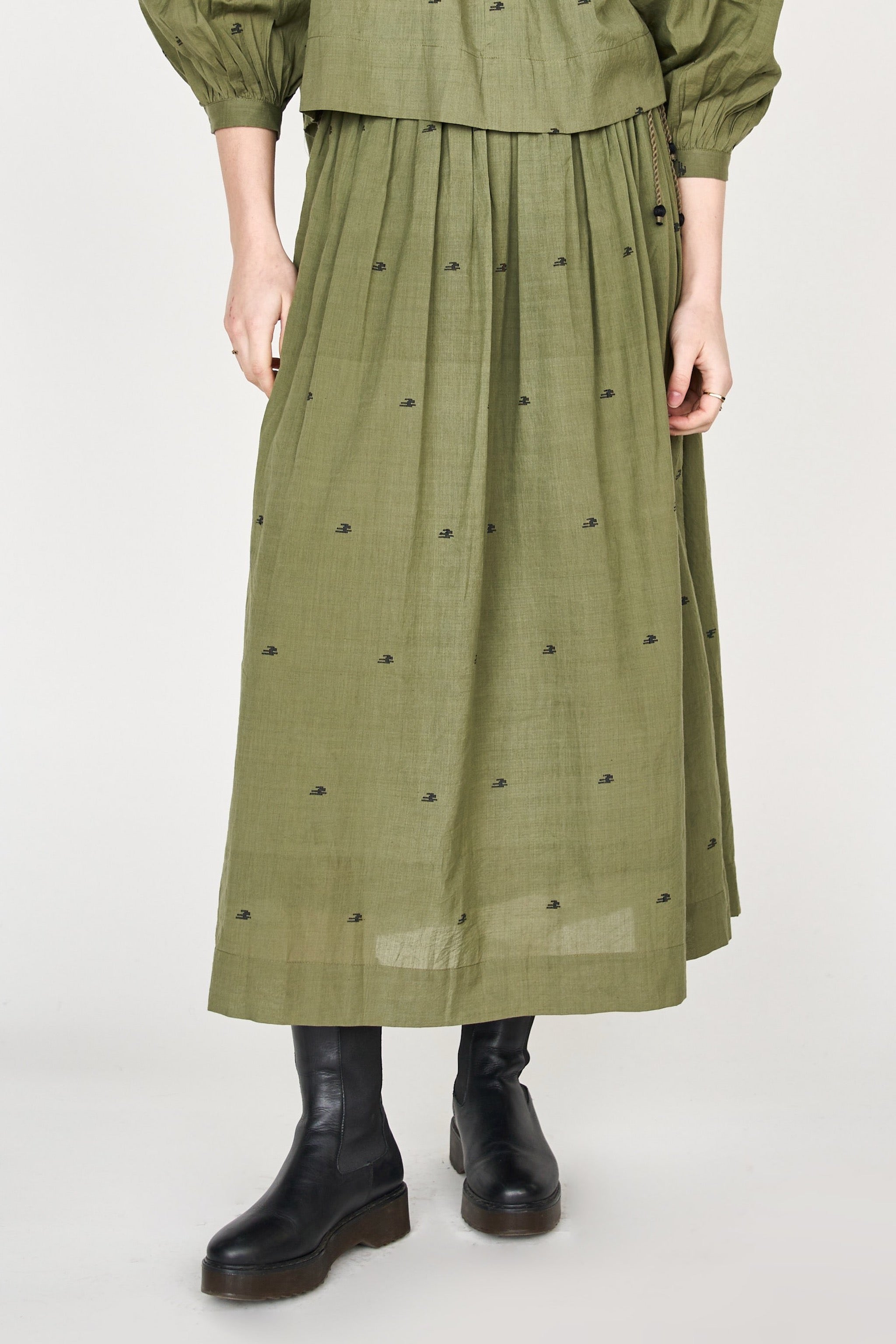 Girl wearing MIRTH women's lowy maxi verona vacation skirt in handloomed jamdani olive green cotton