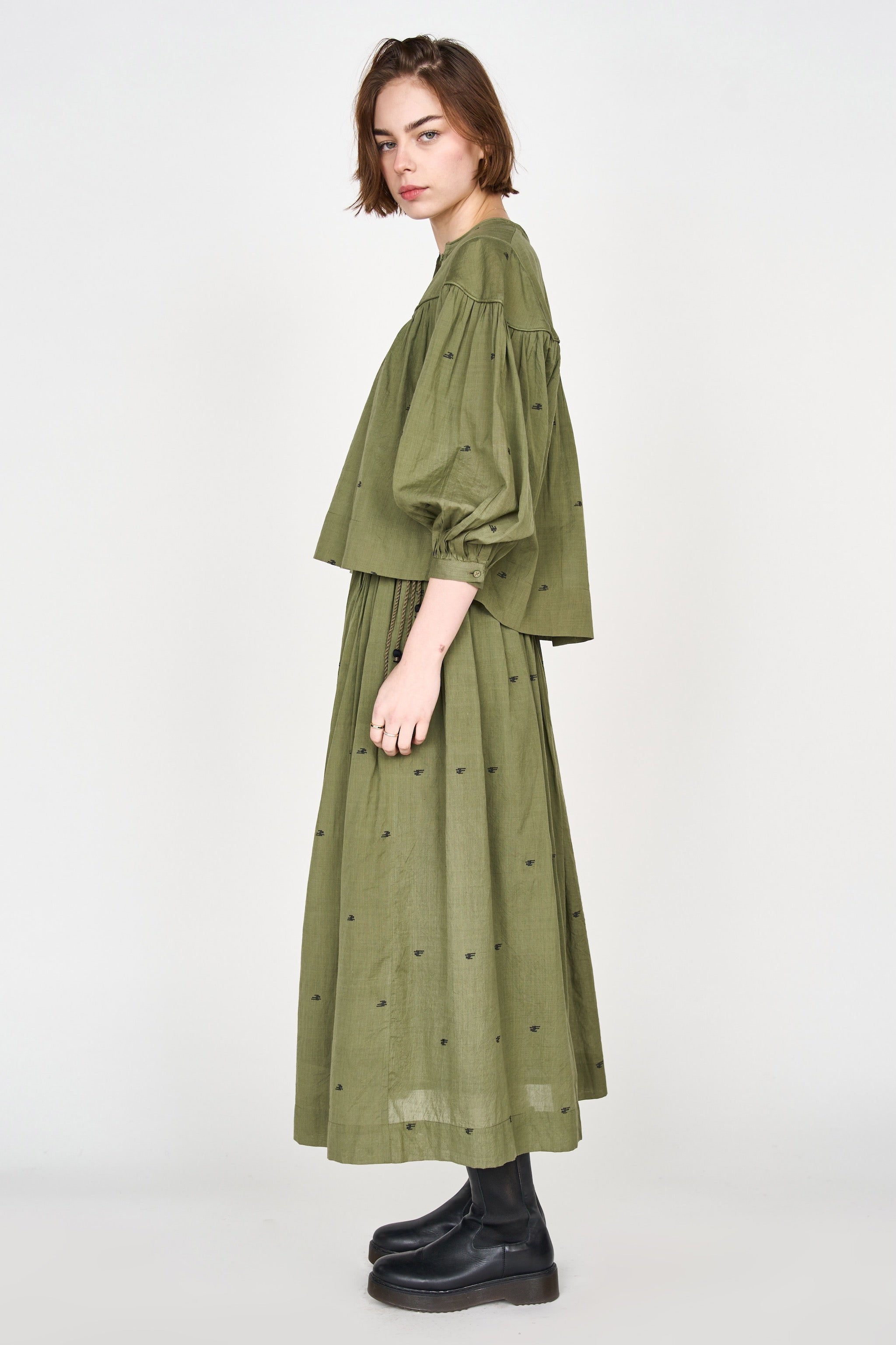 Girl wearing MIRTH women's lowy maxi verona vacation skirt in handloomed jamdani olive green cotton