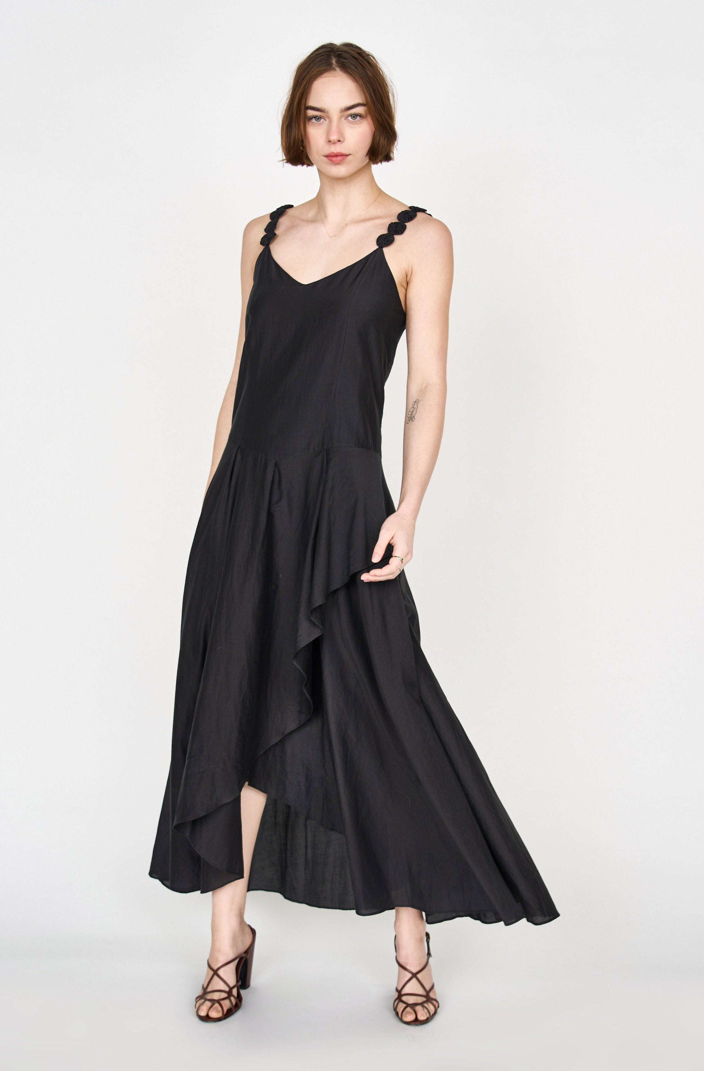 Girl wearing MIRTH women's long singapore spaghetti strap drop waist dress in black cotton silk